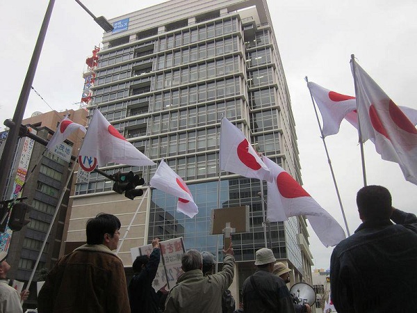 新築された沖縄タイムスビル前で抗議する市民